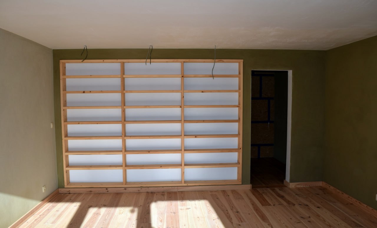 Enduit à l'argile — pièce vert olive avec bibliothèque bois