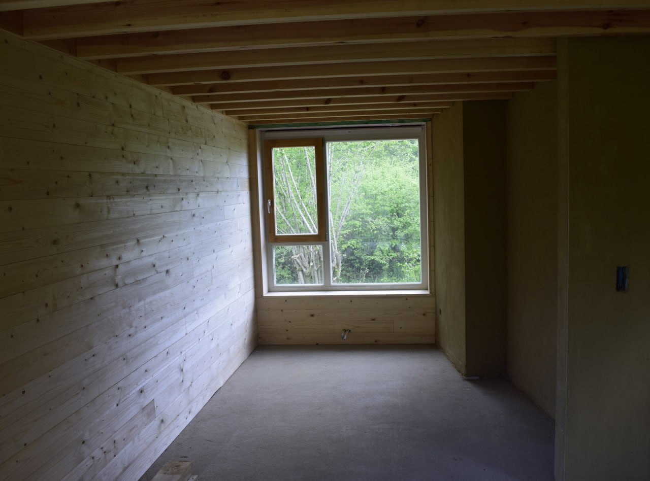 Bardage intérieur en sapin — pièce avec solives apparentes