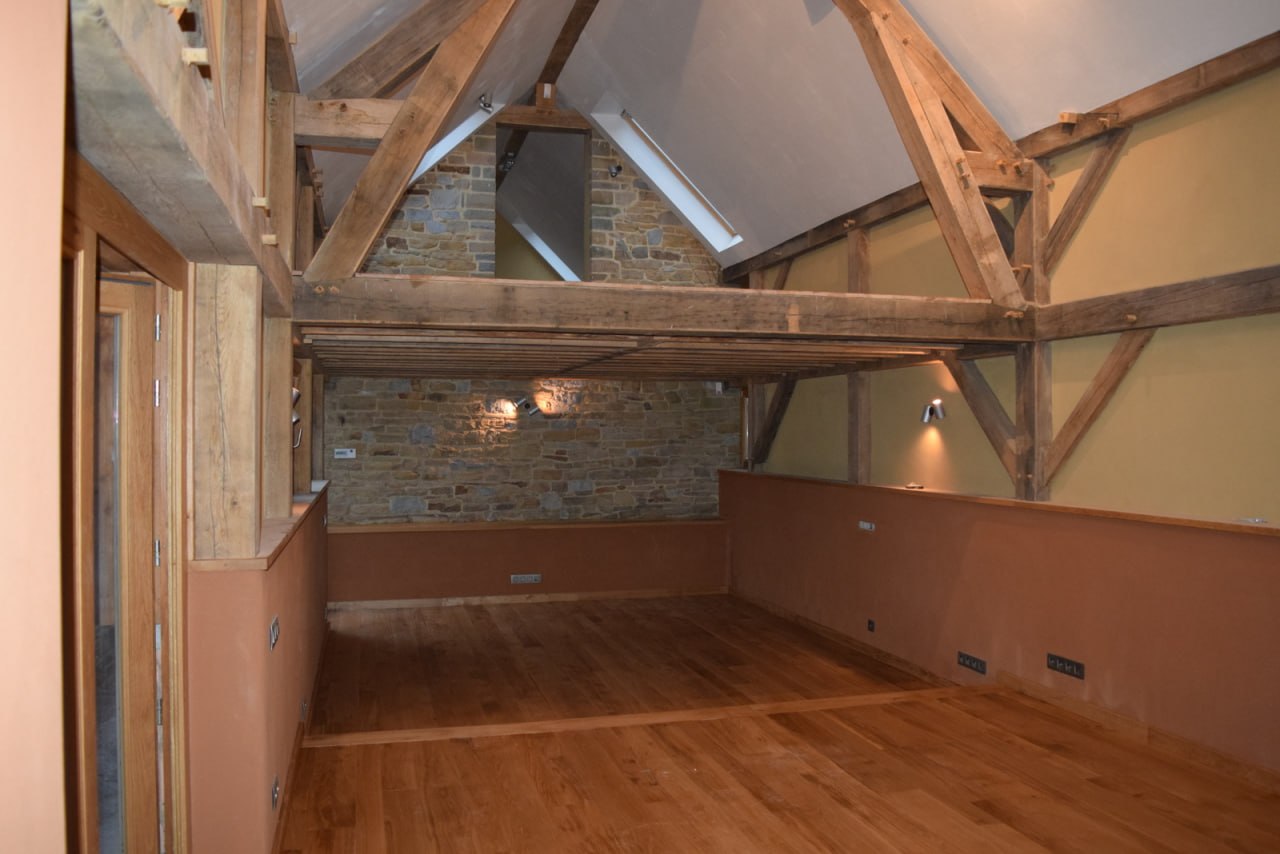 Plancher chêne — niveau supérieur grange rénovée, charpente et mur pierres